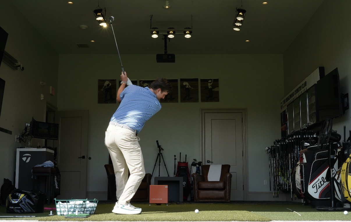 Donnie Breneman moving through the golf swing into a balanced finish in the indoor performance center.